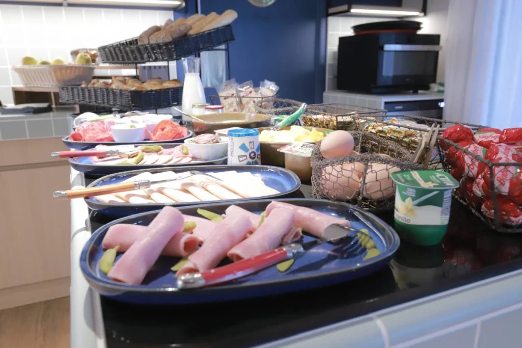Buffet petit-déjeuner de l’Hôtel Antares & Spa Honfleur avec charcuterie, produits frais, pains, fromages et viennoiseries.