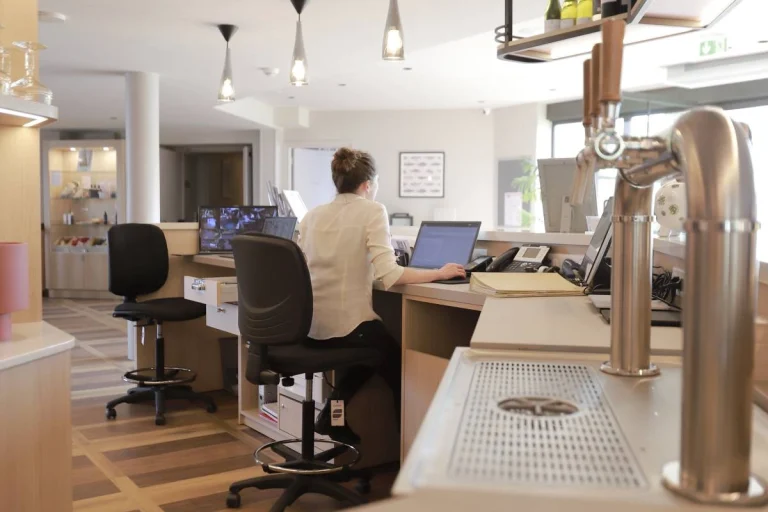 Réception de l’Hôtel Antares & Spa Honfleur, avec personnel à l’accueil, espace lumineux et services d’informations utiles.