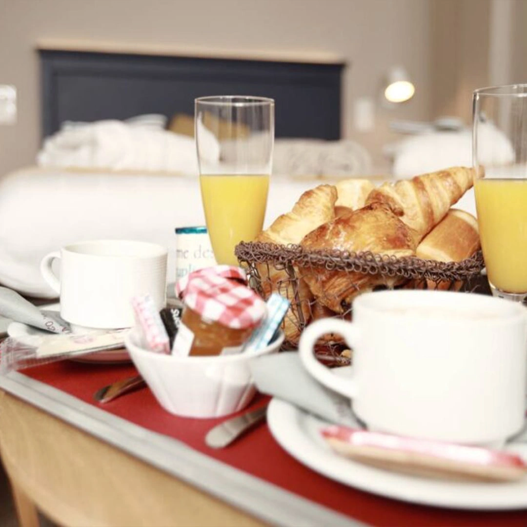 Visuel de l’offre L’Échappée Belle : 1 nuitée à l’Hôtel Antares & Spa Honfleur, montrant une ambiance gourmande avec viennoiseries et boissons.