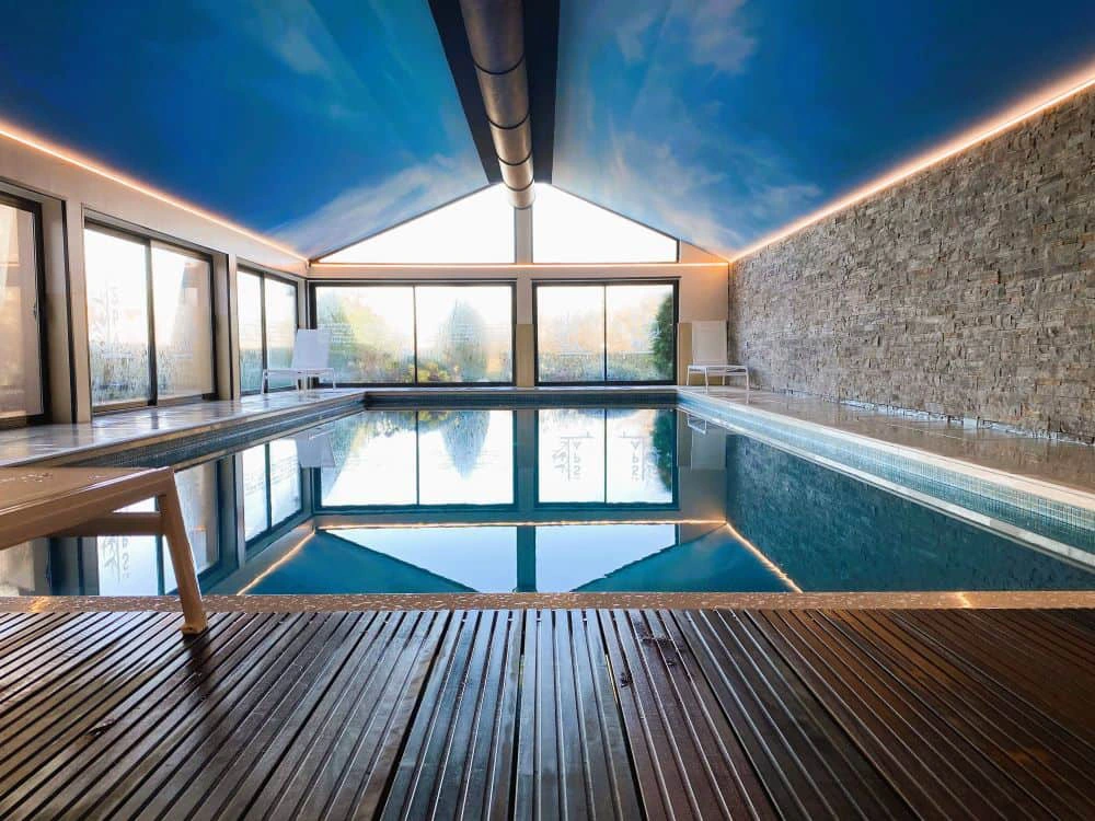 Piscine intérieure chauffée de l’Hôtel Antares à Honfleur avec grandes baies vitrées