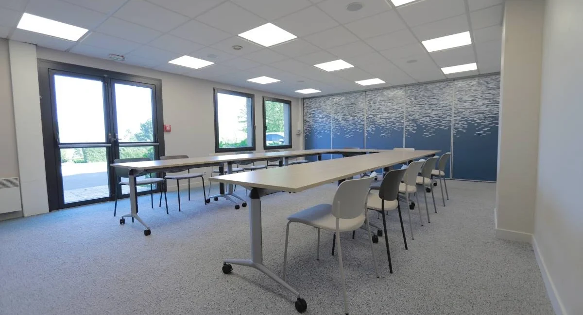 Salle de séminaire lumineuse de l’Hôtel Antares à Honfleur avec tables en configuration U